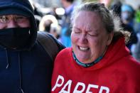 A woman reacts to pepper spray deployed by police at a Get Out The Vote march in Graham