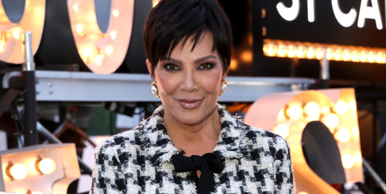 kris jenner wearing a black and white houndstooth style patterned jacket and skirt with an all black pleated leather chanel bag