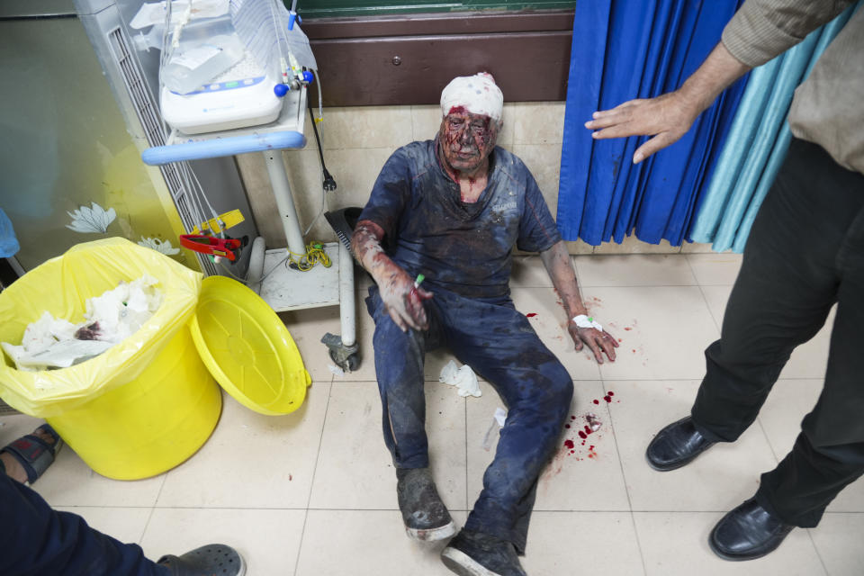 A Palestinian wounded in the Israeli bombardment of the Gaza Strip sits on the floor at Al-Aqsa Hospital in Deir Al-Balah, Wednesday, Oct. 18, 2023. (AP Photo/Hatem Moussa)