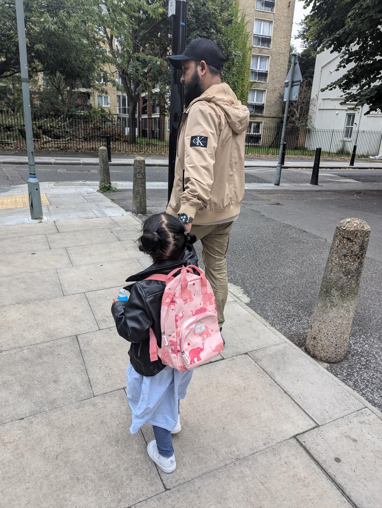 Yumna holds hands with her father Matin as she heads to school in Bethnal Green, east London (Family handout/Gosh Charity/PA)