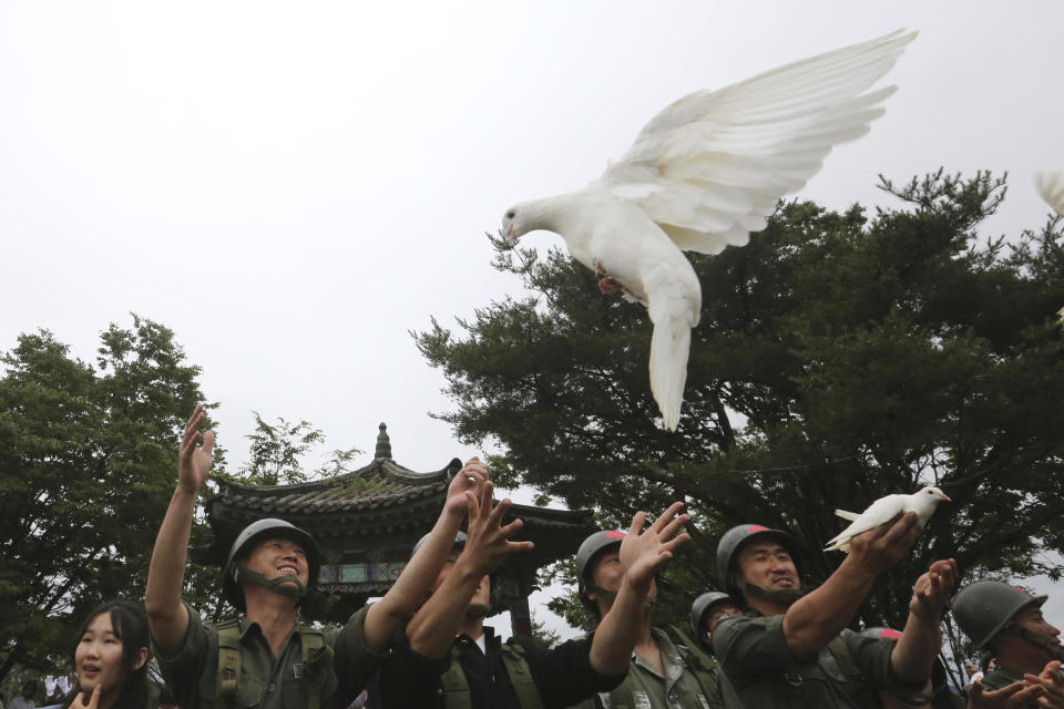 Actors wearing military uniforms release pigeons during a ceremony to mark the 70th anniversary of the outbreak of the Korean War in Cheorwon, near the border with North Korea, South Korea, Thursday, June 25, 2020. The three-year Korean War broke out on June 25, 1950, when Soviet tank-led North Koreans invaded South Korea. (AP Photo/Ahn Young-joon)