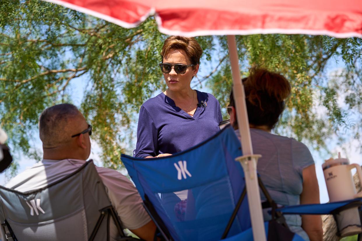 Gubernatorial candidate Kari Lake speaks with Tony and Suzane Ortiz while they watch their son play football at South Mountain Pavilion at Tumbleweed Park in Chandler on Aug. 27, 2022.