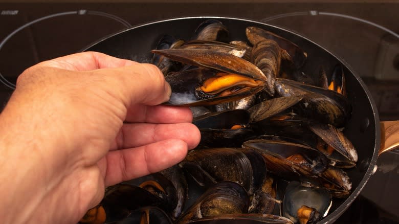 Open mussel in hand