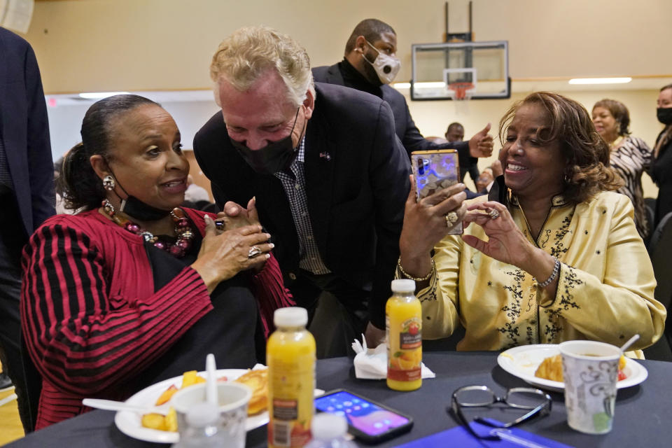 Democratic gubernatorial candidate, former Gov. Terry McAuliffe, center, greets supporters during a rally in Richmond, Va., Thursday, Oct. 28, 2021. McAuliffe will face Republican Glenn Youngkin in the November election. (AP Photo/Steve Helber)