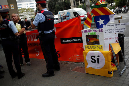 Catalan Mossos d'Esquadra officers prohibit Catalan National Assembly (ANC) member and public worker of the Terrassa's town hall, Pep Rovira, his protest in favor of the banned October 1 independence referendum at Catalunya square in Barcelona, Spain, September 26, 2017. REUTERS/Jon Nazca