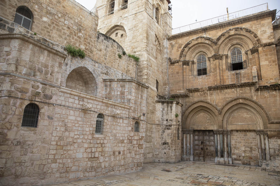 This Friday, April 10, 2020 photo shows the Church of the Holy Sepulchre, believed by many Christians to be the site of the crucifixion and burial of Jesus Christ, in Jerusalem's Old City. Christians are commemorating Jesus' crucifixion without the solemn church services or emotional processions of past years, marking Good Friday in a world locked down by the coronavirus pandemic. (AP Photo/Sebastian Scheiner)