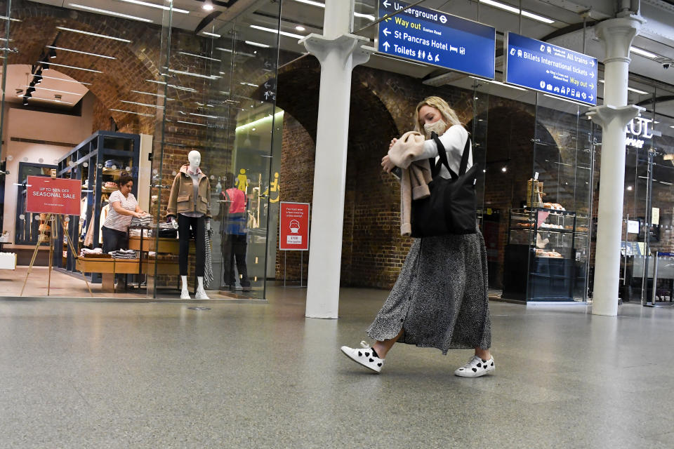 A woman wears a face mask, to protect against infection from coronavirus, as she walks in St Pancras Station, in London, Tuesday, Sept. 8, 2020. (AP Photo/Alberto Pezzali)