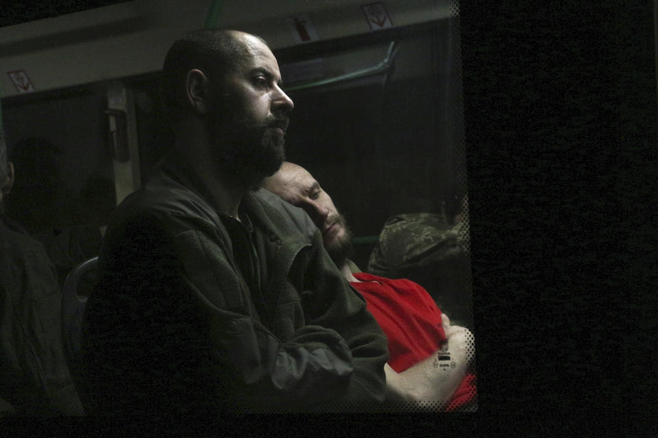 Ukrainian servicemen sit in a bus after they were evacuated from the besieged Mariupol's Azovstal steel plant, near a prison in Olyonivka, in territory under the government of the Donetsk People's Republic, eastern Ukraine, Tuesday, May 17, 2022. More than 260 fighters, some severely wounded, were pulled from a steel plant on Monday that is the last redoubt of Ukrainian fighters in the city and transported to two towns controlled by separatists, officials on both sides said. (AP Photo)