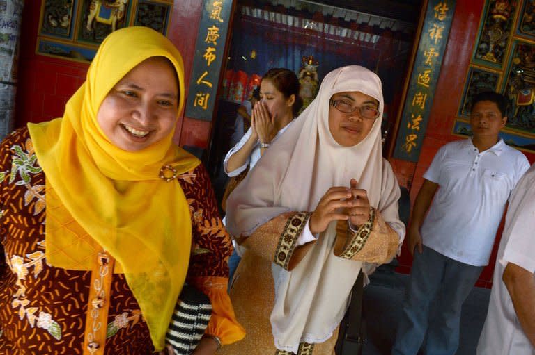 Muslim women Lusi Kusuma (L) and Widi Astuti visit a Buddhist temple in the Indonesian capital city of Jakarta on February 8, 2013 as minority Chinese-Indonesians celebrate the Lunar New Year. As Indonesia and other countries with Chinese diasporas welcome the Year of the Snake, hardline Islamic leaders have ignited a religious row by declaring the celebrations 'haram' and off limits for Muslims