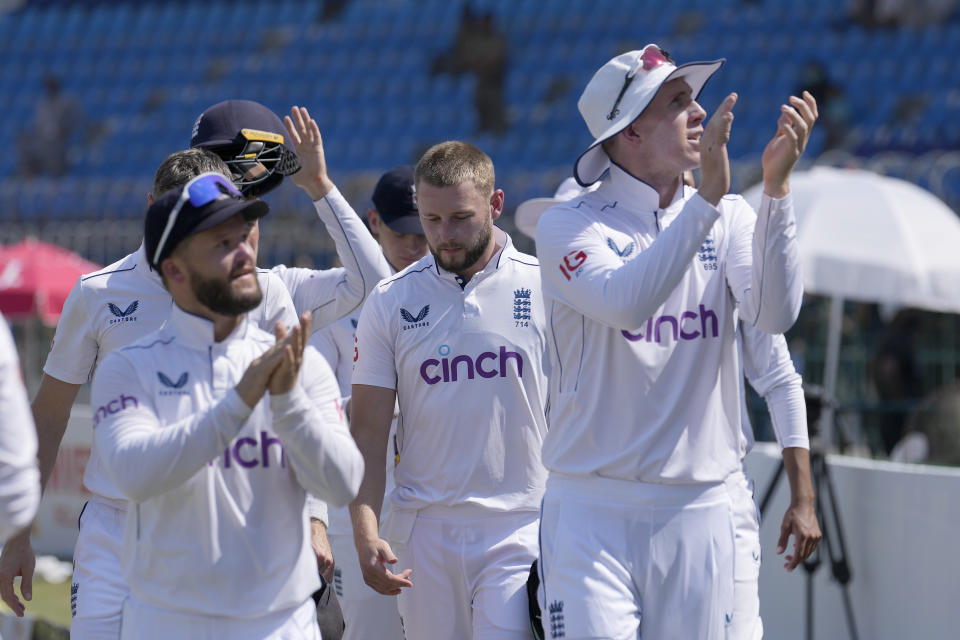 England's Zak Crawley, right, and teammates acknowledge crowd as they walk off the field after winning the first test cricket match against Pakistan, in Multan, Pakistan, Friday, Oct. 11, 2024. (AP Photo/Anjum Naveed)