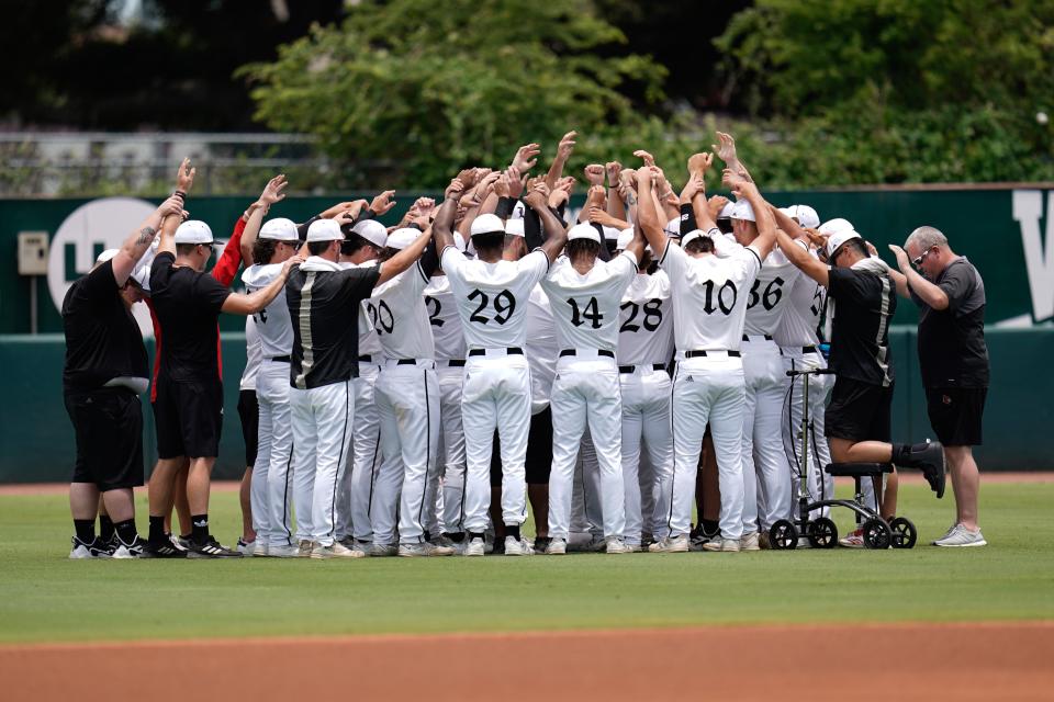 Jun 11, 2022; College Station, TX, USA; Louisville players huddle prior to game 2 of the Super Regional series against Texas A&M.  Mandatory Credit: Chris Jones-USA TODAY Sports