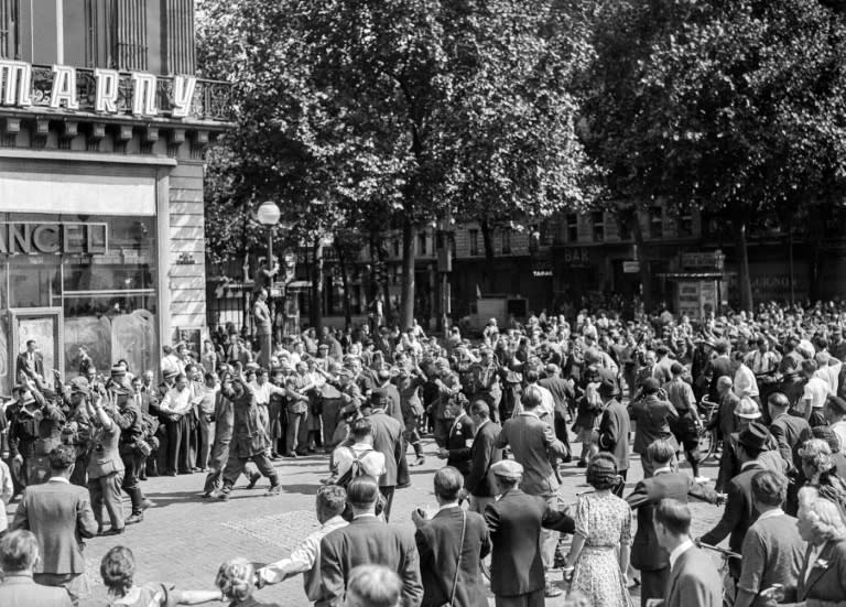 Una multitud observa a unos soldados alemanes capturados el 25 de agosto de 1944 en la Plaza de la Ópera de París, tras su rendición y la toma del edificio Kommandantur, durante la batalla por la liberación de París en la Segunda Guerra Mundial (-)