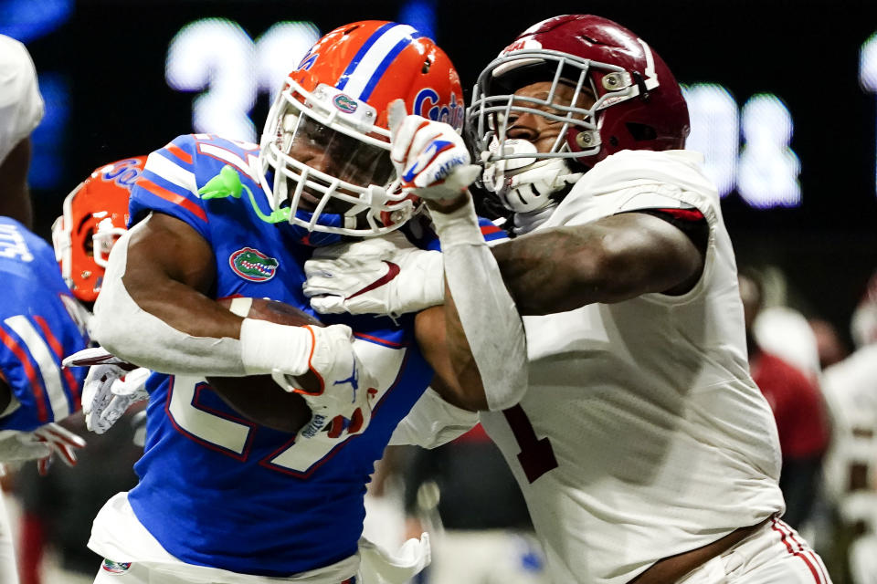 Florida running back Dameon Pierce (27) runs into the end zone for a touchdown against Alabama linebacker Ben Davis (1) during the second half of the Southeastern Conference championship NCAA college football game, Saturday, Dec. 19, 2020, in Atlanta. (AP Photo/Brynn Anderson)