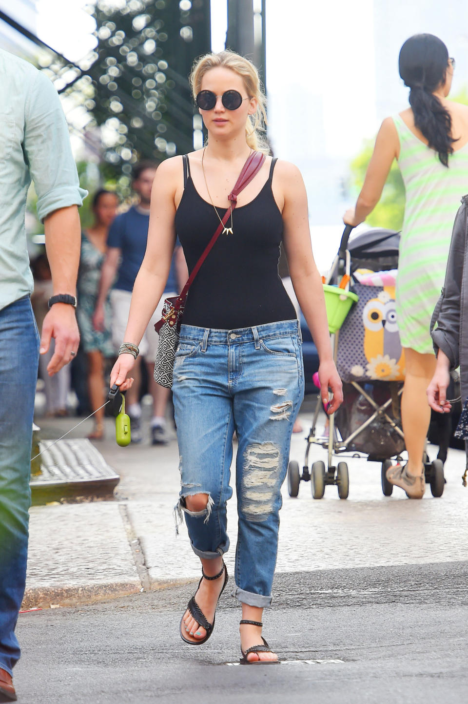 Jennifer Lawrence in a simple black tank and ripped up boyfriend jeans.