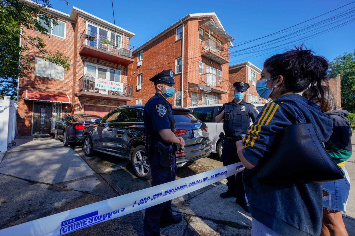 Deborah Torres , right, talks to police officers stand outside her home in the Queens borough of New York where some of the occupants died including a 2-year old child when their basement apartment flooded, Thursday, Sept. 2, 2021, in New York.