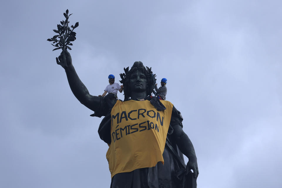 Activists draped the statue on Place de la Republique with a banner reading "Macron resign" during a demonstration, Monday, May 1, 2023 in Paris. French unions plan massive demonstrations around France to protest President Emmanuel Macron's recent move to raise the retirement age from 62 to 64. (AP Photo/Aurelien Morissard)
