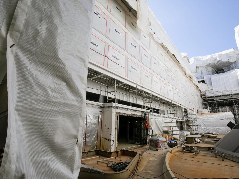 An incomplete outdoor space with tarp, construction equipment on Royal Caribbean's Icon of the Seas cruise ship under construction.