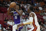 Sacramento Kings guard Davion Mitchell (15) prepares to pass past Miami Heat center Bam Adebayo during the first half of an NBA basketball game, Wednesday, Nov. 2, 2022, in Miami. (AP Photo/Wilfredo Lee)