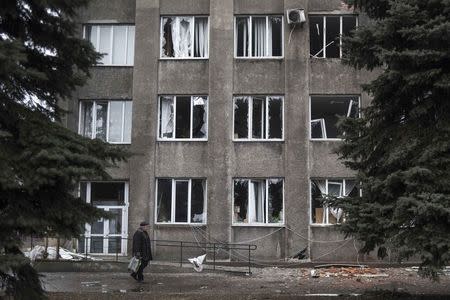 A man walks past the damaged city council building in Debaltseve, February 3, 2015. REUTERS/Sergey Polezhaka