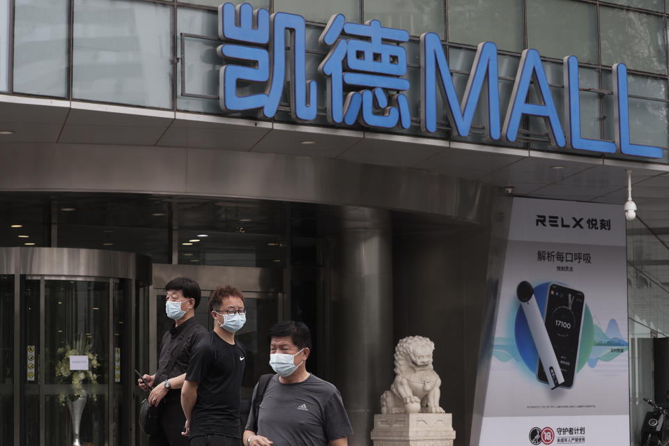 People wearing protective face masks to help curb the spread of the new coronavirus gather outside a shuttered shopping mall following positive cases detected at the mall in Beijing, Tuesday, June 23, 2020. China reported close to two dozen new cases of coronavirus on Tuesday a day after a city government spokesperson said containment measures had slowed the momentum of an outbreak in the capital that has infected more than 200 people. (AP Photo/Andy Wong)