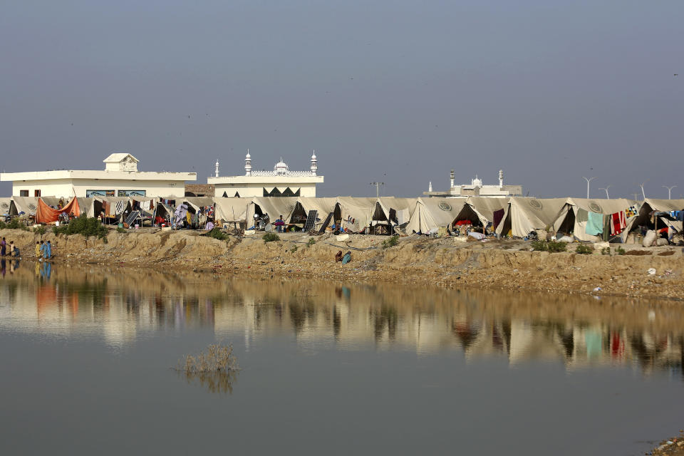 People take refuge in a relief camp setup on a higher ground surrounded by floodwaters, in Jaffarabad, a flood-hit district of Baluchistan province, Pakistan, Oct. 25, 2022. Residents of Pakistan's poorest province, Baluchistan, say they are being neglected in recovery efforts after last summer's devastating floods. Around 75% of Baluchistan's population was affected by the flood, the highest proportion of any province in the country. (AP Photo/Fareed Khan)