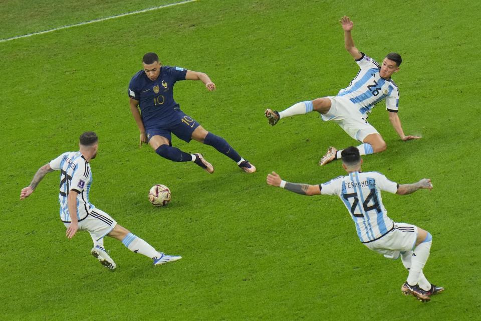 France's Kylian Mbappe, center, controls the ball during the World Cup final soccer match between Argentina and France at the Lusail Stadium in Lusail, Qatar, Sunday, Dec. 18, 2022. (AP Photo/Hassan Ammar)