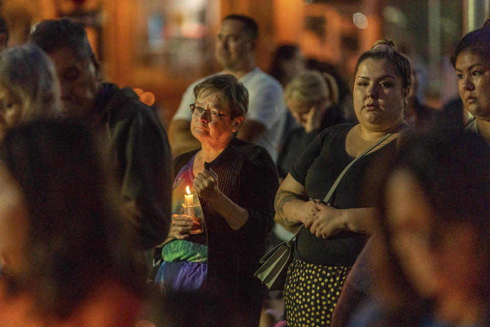 A mourner holds a candle at a vigil in honor of the victims of a mass stabbing incident at James Smith Cree Nation and Weldon, Saskatchewan, in front of City Hall in Prince Albert, Saskatchewan, on Wednesday, Sept. 7, 2022. (Heywood Yu/The Canadian Press via AP)