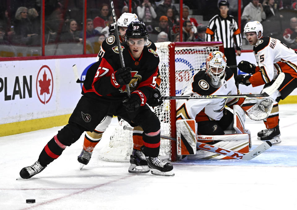 Ottawa Senators center Shane Pinto (57) looks for the puck as Anaheim Ducks center Adam Henrique (14) tries to keep him back during second-period NHL hockey game action in Ottawa, Ontario, Monday, Dec. 12, 2022. (Justin Tang/The Canadian Press via AP)