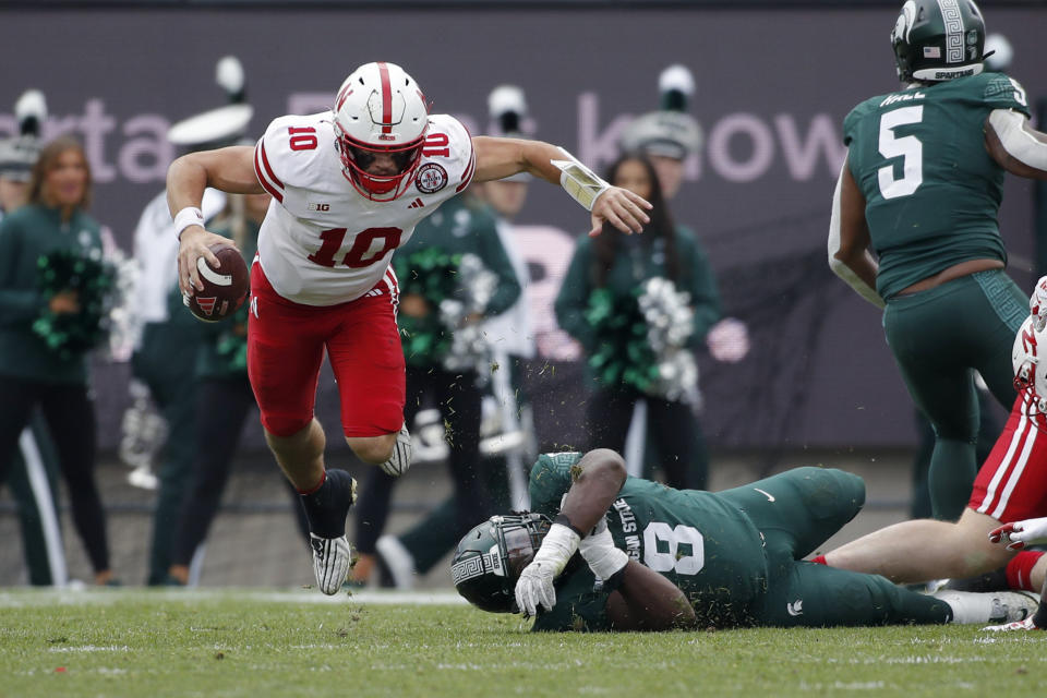 Nebraska quarterback Heinrich Haarberg, left, escapes from Michigan State defensive lineman Simeon Barrow Jr. (8) for a first down during the first half of an NCAA college football game, Saturday, Nov. 4, 2023, in East Lansing, Mich. (AP Photo/Al Goldis)