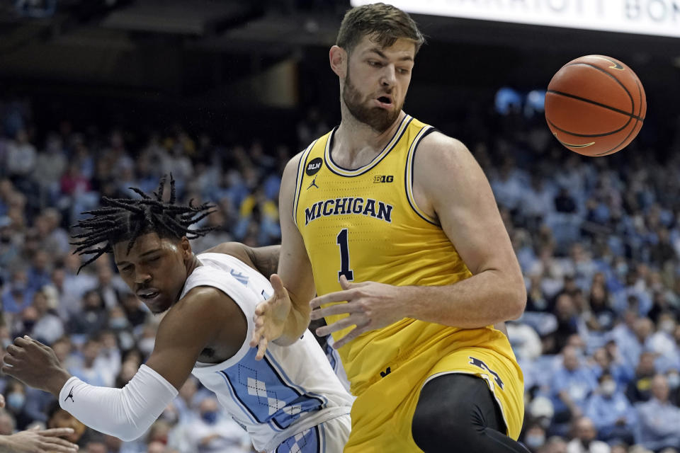 North Carolina guard Caleb Love, left, and Michigan center Hunter Dickinson (1) chase a rebound during the first half of an NCAA college basketball game in Chapel Hill, N.C., Wednesday, Dec. 1, 2021. (AP Photo/Gerry Broome)