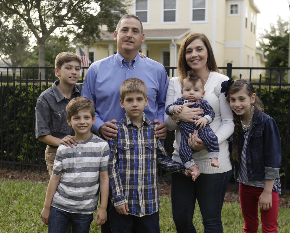 In this Tuesday, Feb. 7, 2017 photo, Francisco and Lauren Nieves-Taranto, center, with their children, from left, Sebastien, 13, Javier, 6, Gabriel, 10, Nicolas 4-months, and Valentina, 8, at their home in Windermere, Fla. Nieves-Taranto covered the entire $8,000 bill from the birth of Nicolas last year with his account balance from a health savings account, or HSA. (AP Photo/John Raoux)