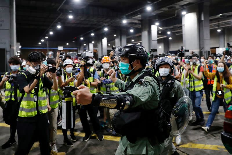FILE PHOTO: A riot police holds a pepper spray as he tries to disperse anti-government protesters after a vigil to mourn student’s death, in Hong Kong