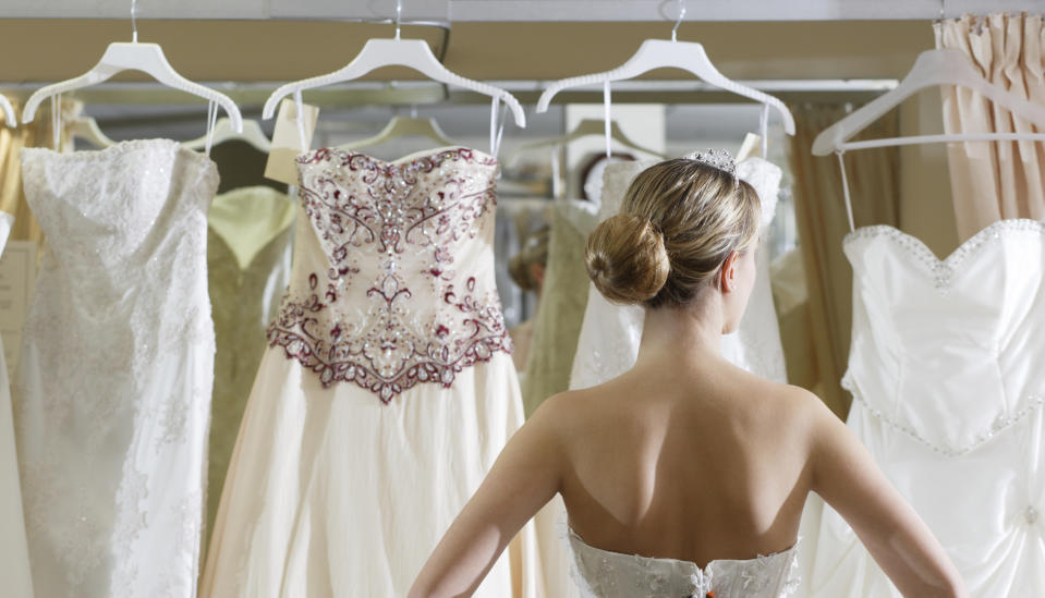Woman looks at row of wedding gowns don't wear a wedding dress to someone else's wedding