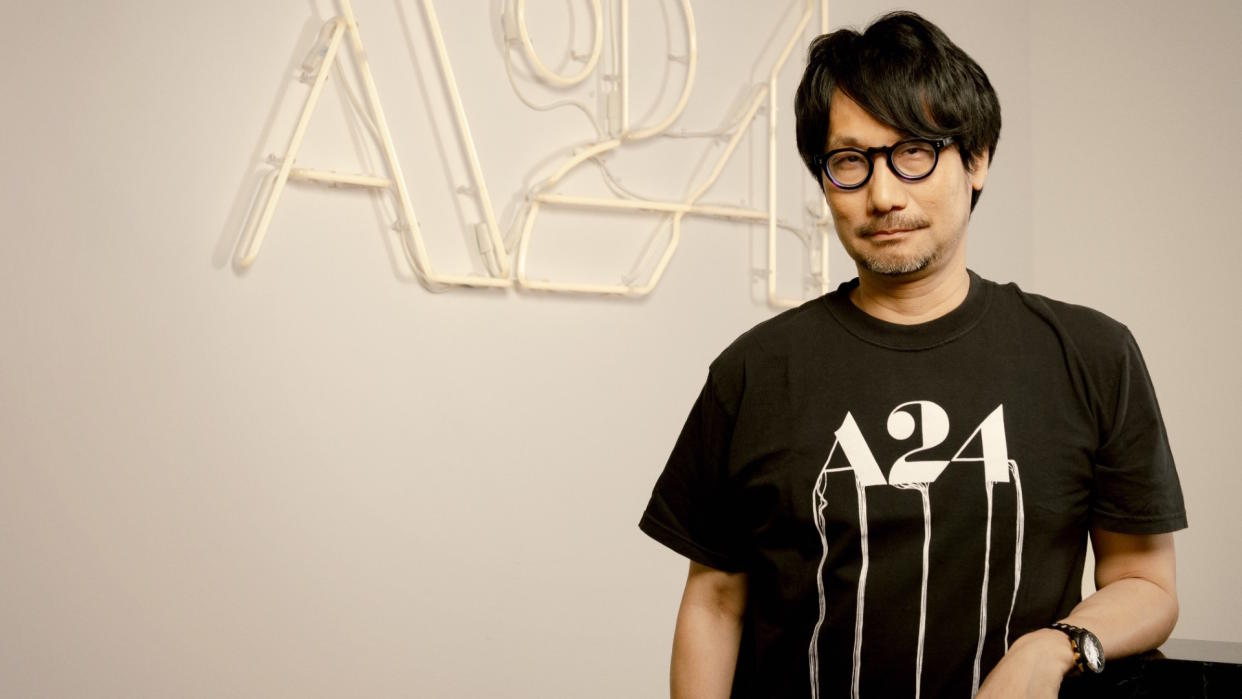  Hideo Kojima standing in front of an A24 logo. 