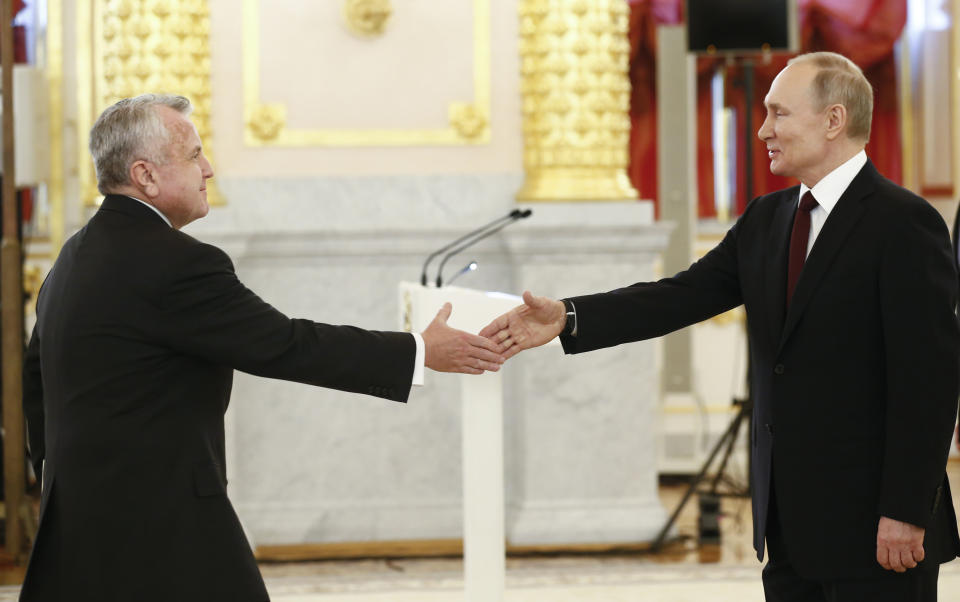 FILE - In this file photo taken on Wednesday, Feb. 5, 2020, Russian President Vladimir Putin, right, and the new U.S. Ambassador to Russia John Sullivan shake hands during a ceremony to receive credentials from newly appointed foreign ambassadors to Russia in Kremlin, in Moscow, Russia. Sullivan said he was heading home for consultations and would return to Moscow in the nearest weeks. (AP Photo/Alexander Zemlianichenko, Pool, File)