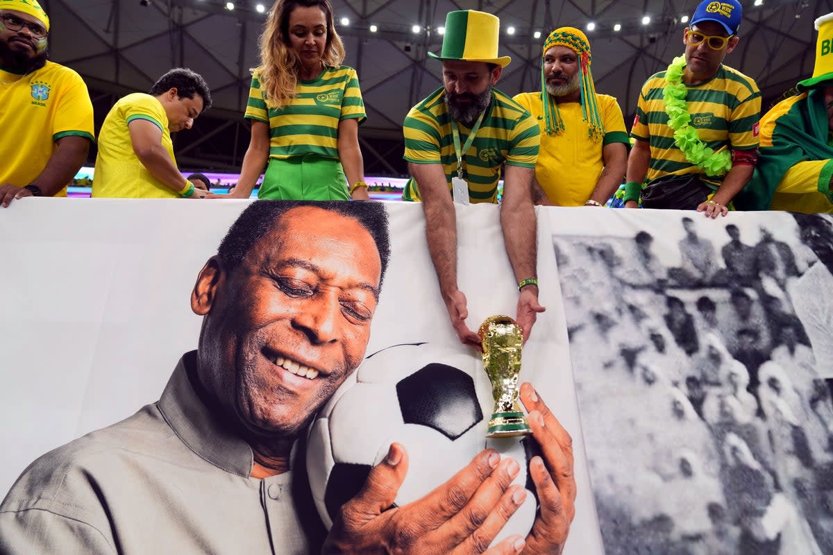 A picture of Pele held up by Brazil fans during a match in Qatar (Peter Byrne/PA) (PA Wire)