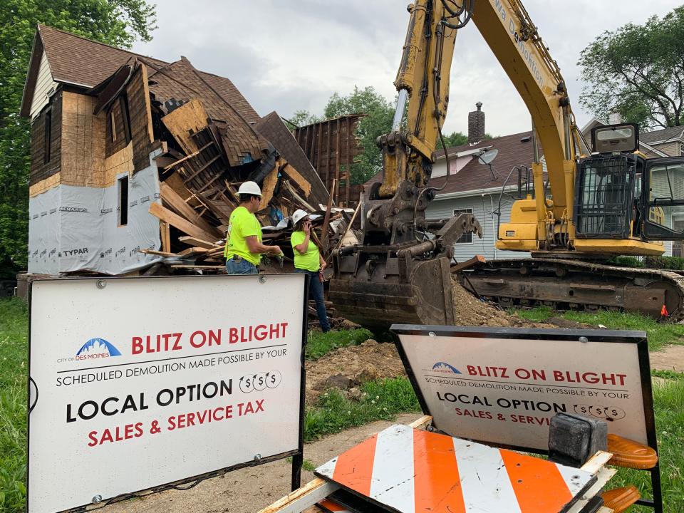 A backhoe works to demolish a house on 11th Street in the Cheatom Park Neighborhood in June 2019.