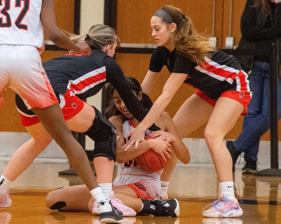 York Suburban’s Alyssa Daugherty, left, and a teammate wrap up Central York’s Alivia McCaskell (31) on a loose ball in a YAIAA quarterifinal on Saturday, Feb. 11, 2023. Central won 50-37.