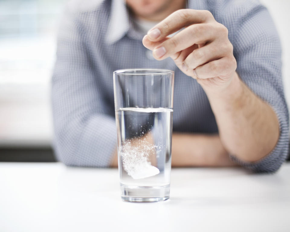 person dropping alka seltzer in water