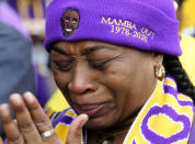 Lioness Saxa cries as she watches the live stream of a public memorial for Kobe Bryant and his daughter, Gianna, outside the Staples Center in Los Angeles, Monday, Feb. 24, 2020. (AP Photo/Ringo H.W. Chiu)