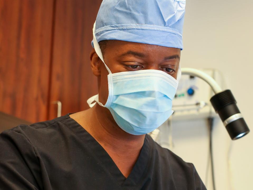 New Jersey-based plastic surgeon Dr. Carlos Burnett in office wearing mask and gloves