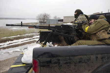 Ukrainian servicemen fire a machine gun in the village near Mariupol, a city on the Sea of Azov, January 26, 2015. REUTERS/Maksim Levin