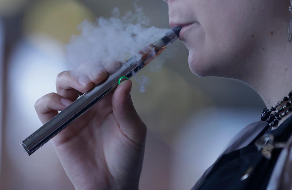 In this Oct. 4, 2019, photo, a woman using an electronic cigarette in Mayfield Heights, Ohio.