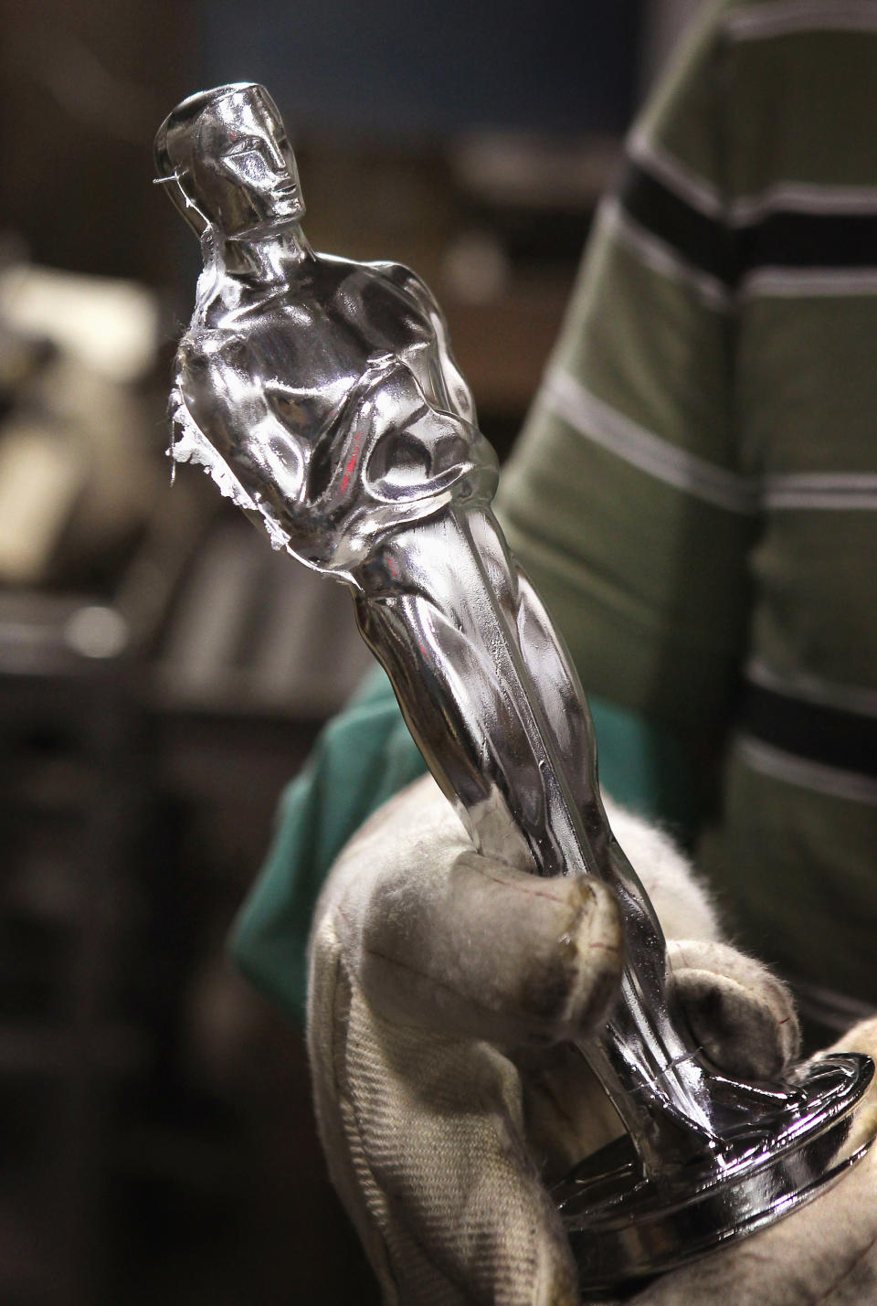 CHICAGO, IL - FEBRUARY 09: Martin Vega inspects an Oscar statuette he cast at R.S. Owens & Company February 9, 2012 in Chicago, Illinois. R.S. Owens manufactures the Oscar statuettes which are presented at the annual Academy Awards by the Academy of Motion Picture Arts and Sciences. After the theft of the statuettes prior to the 2000 Academy Awards the company began casting the statuettes one year in advance of the show. (Photo by Scott Olson/Getty Images)