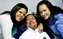 Hugo Chavez smiles in between two of his daughters, Rosa (R) and Maria while recovering from cancer surgery in Havana, Cuba. This photograph became a symbol for supporters as little news of the President's condition was released towards the end of his death (Reuters)