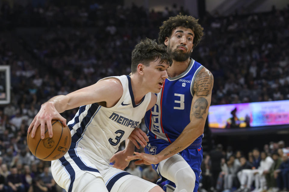 Memphis Grizzlies forward Jake LaRavia, left, drives past Sacramento Kings guard Chris Duarte during the first half of an NBA basketball game in Sacramento, Calif., Monday, March 18, 2024. (AP Photo/Randall Benton)