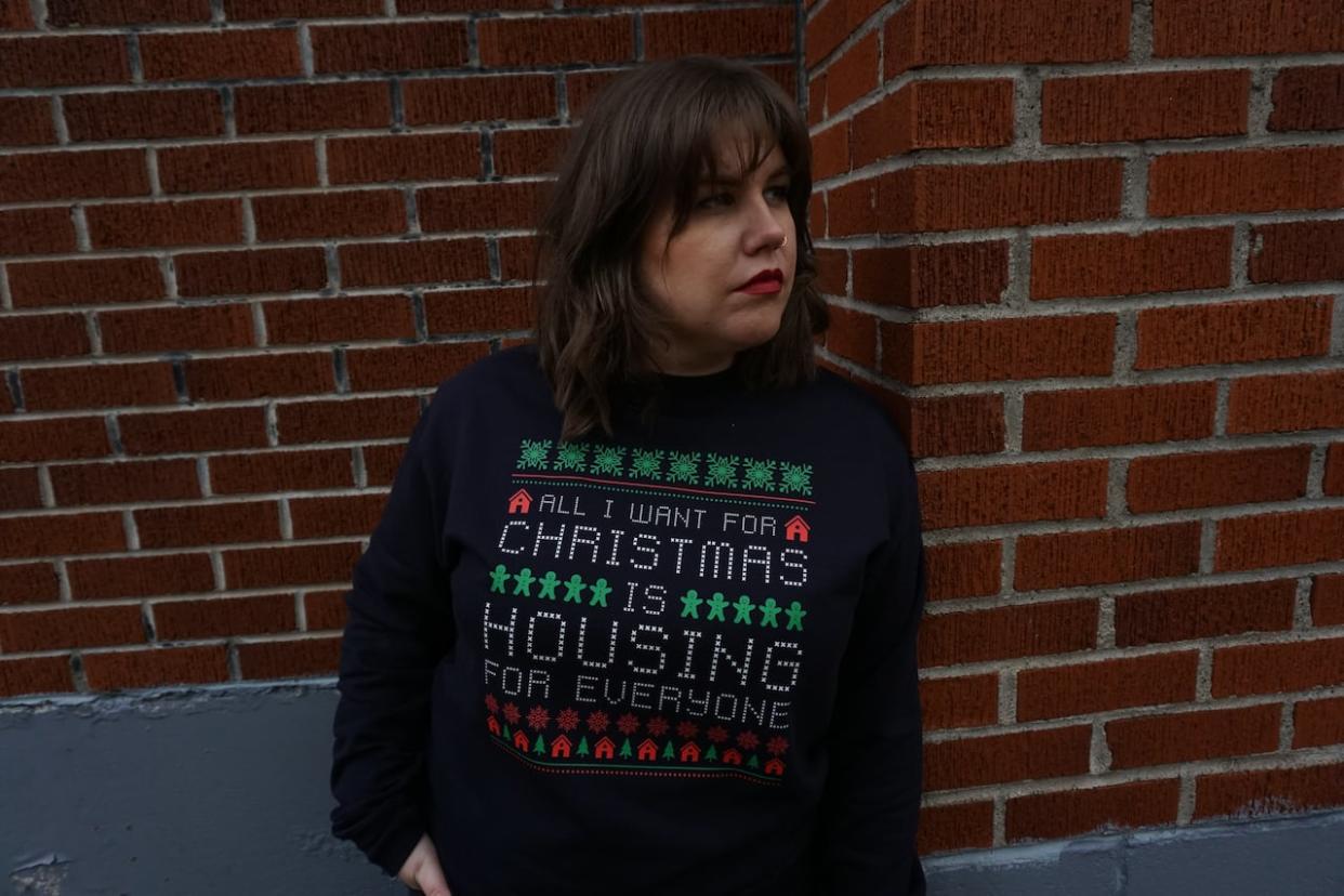 Cass Elliot of Make Waves Collective sporting their holiday sweatshirt. Some of the proceeds will benefit the people in need at the tent encampment in Bannerman Park.  (Submitted by Cass Elliot - image credit)