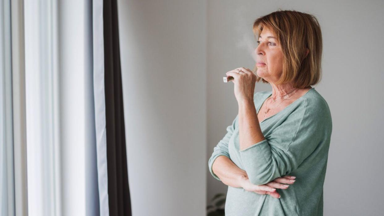 A female using an e-cigarette.