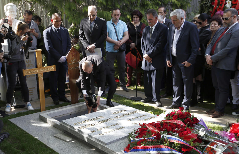 A family friend if Slobodan Bulatovic hands down the urn containing the ashes of Mirjana Markovic, the widow of former strongman Slobodan Milosevic during her funeral at the yard of his estate in his home town of Pozarevac, Serbia, Saturday, April 20, 2019. Markovic died last week in Russia where she had been granted asylum. The ex-Serbian first lady had fled there in 2003 after Milosevic was ousted from power in a popular revolt and handed over to the tribunal in The Hague, Netherlands. (AP Photo/Darko Vojinovic)