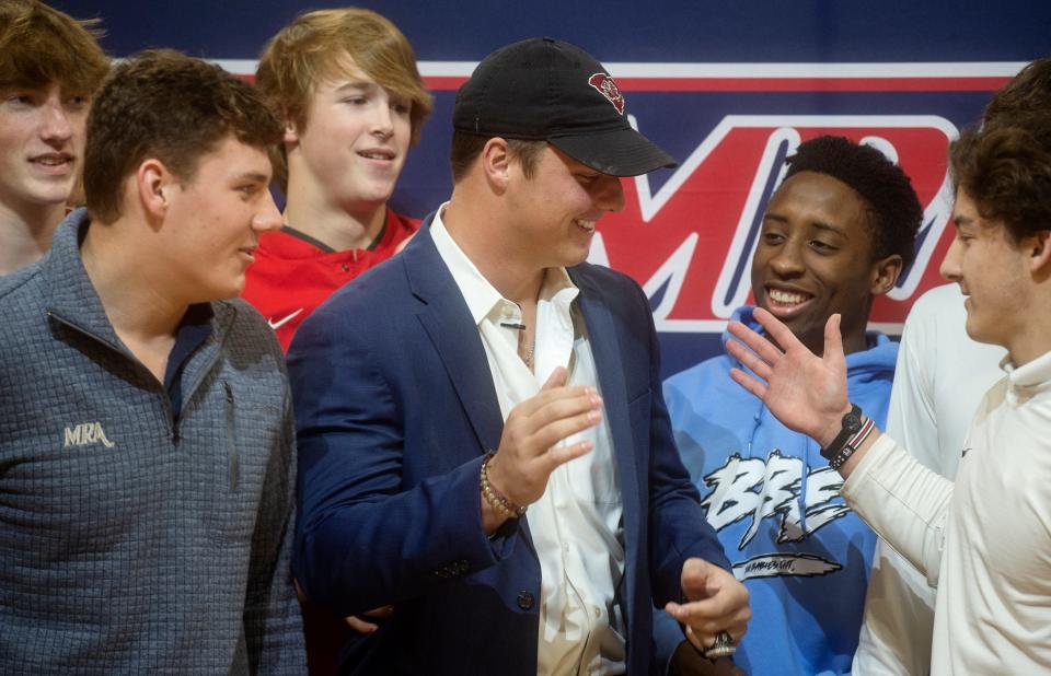 Stone Blanton, a senior linebacker at Madison-Ridgeland Academy, center, is congratulated by his friends and teammates after announcing his commitment to playing football and baseball for the University of South Carolina during a commitment ceremony at Madison-Ridgeland Academy in Madison, Miss., Monday, Dec. 13, 2021. 